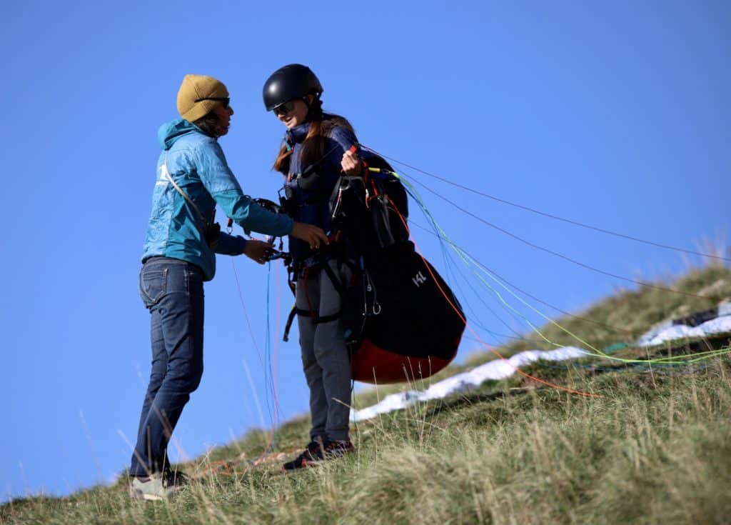 Vérification que l'élève soit bien équipée avant son envol en parapente